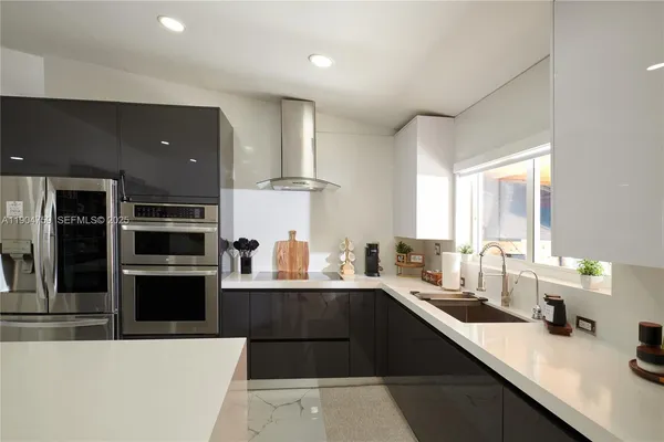 a kitchen with a sink dishwasher a stove and a refrigerator with wooden floor