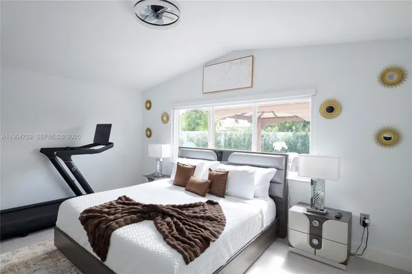 a bedroom with a bed and a large window