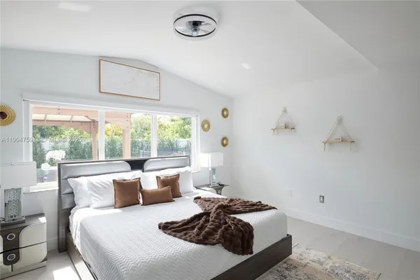 a bedroom with a bed and a large window