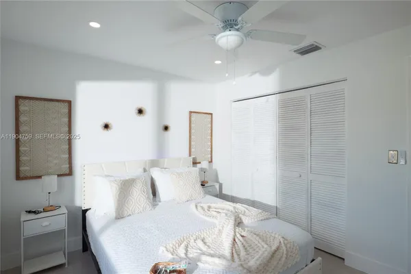 a bedroom with a white bed and a chandelier