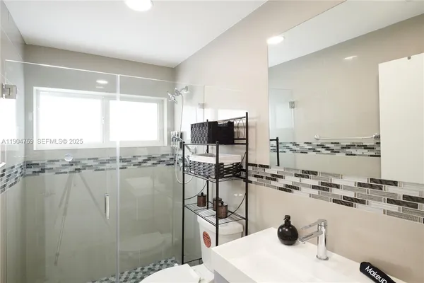 a bathroom with a granite countertop sink and a window