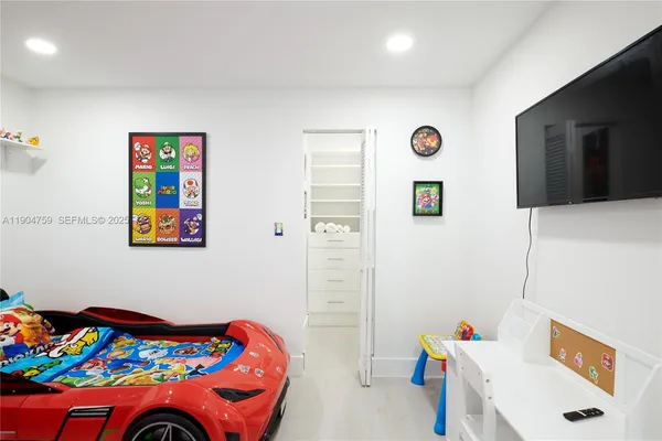 a bedroom with furniture and a flat screen tv