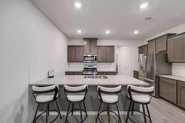 a kitchen with a dining table chairs stove and refrigerator