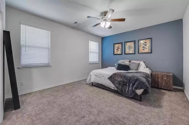 a spacious bedroom with a bed and a chandelier