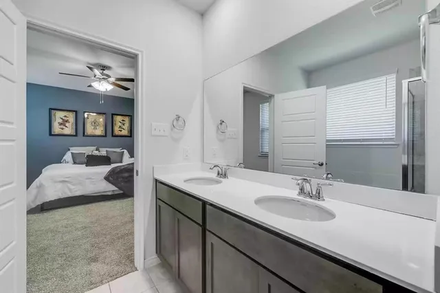 a en suite bathroom with a granite countertop sink and a mirror