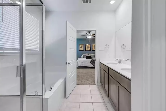 a en suite bathroom with a granite countertop sink and a mirror