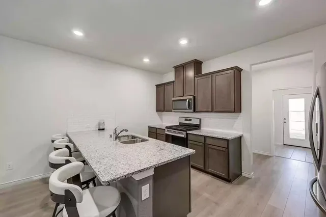 a view of a kitchen with a table and chairs in it