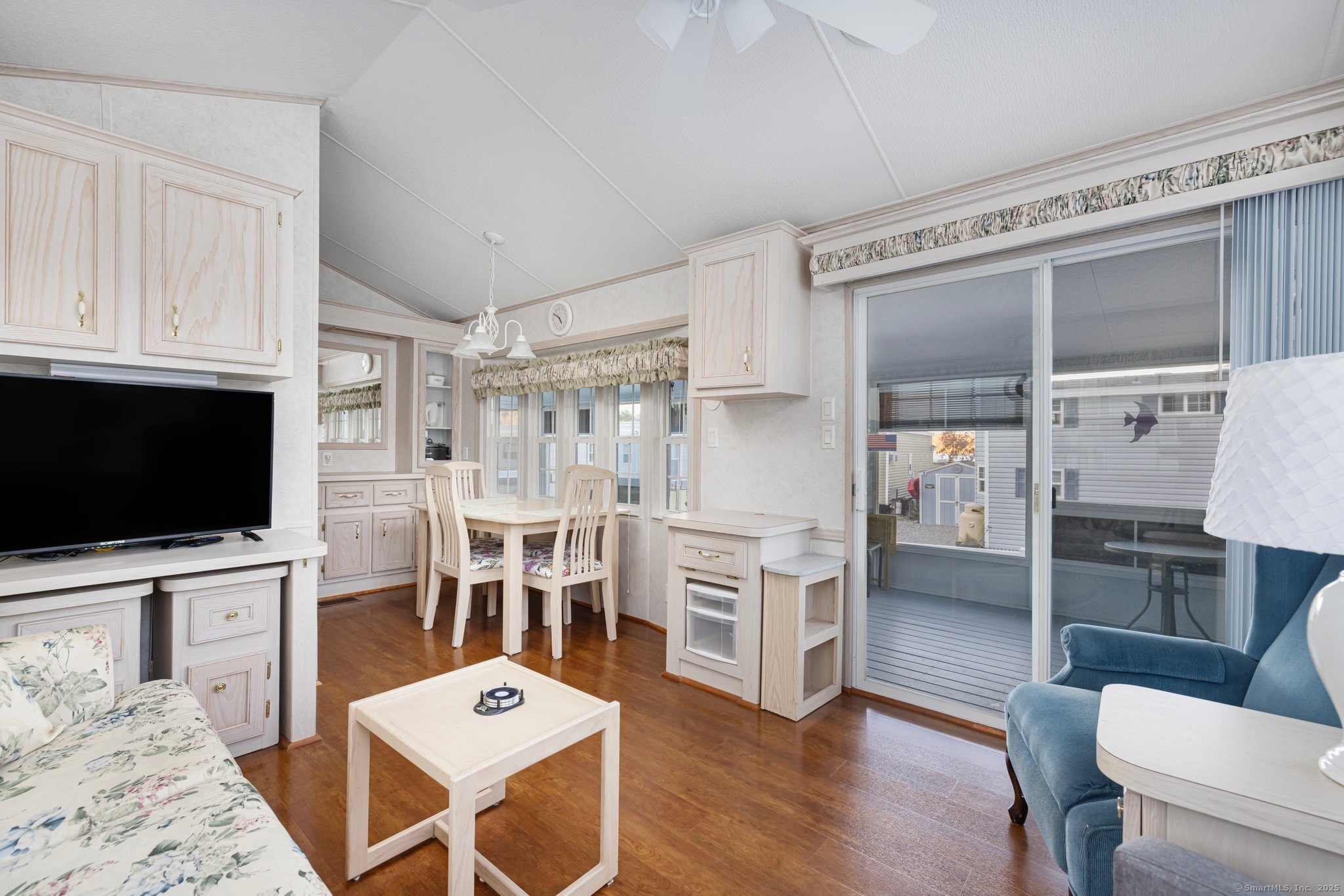 262 Shetucket Turnpike, Unit 69 Griswold, CT 06351 - Photo 15 of 37 a living room with furniture a flat screen tv and kitchen view