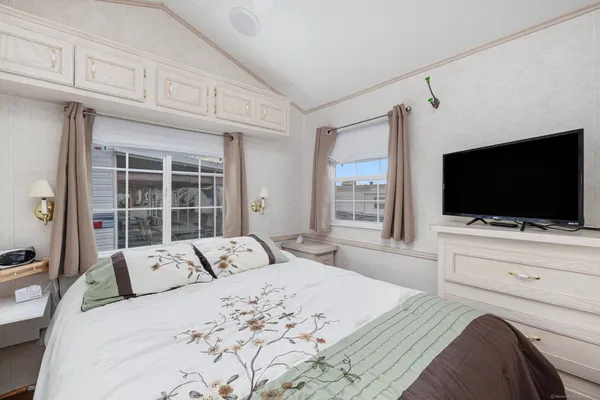 a bedroom with a large bed and a flat screen tv