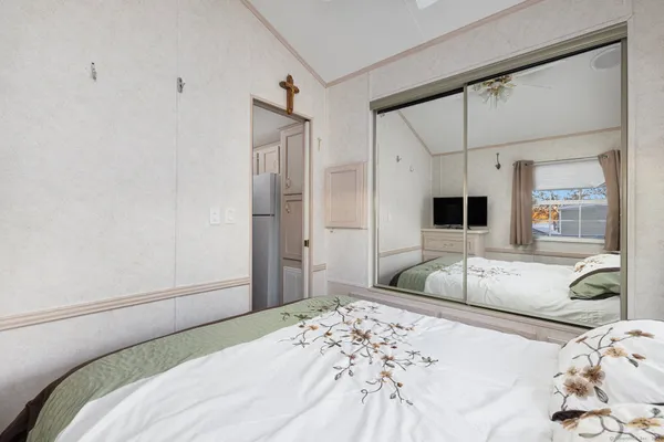 a bedroom with a bed and a large mirror