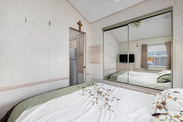 a bedroom with a bed and a large mirror