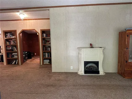 a living room with furniture a rug and a book shelf
