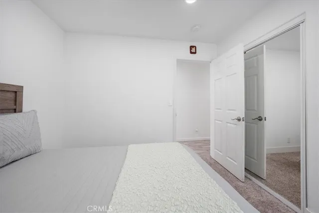 a large bed sitting in a bedroom next to a window