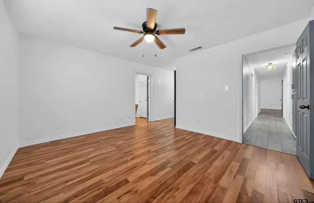 a view of empty room with wooden floor