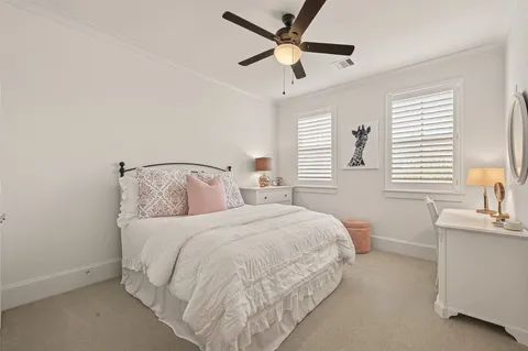 a spacious bedroom with a bed a chandelier and a dresser