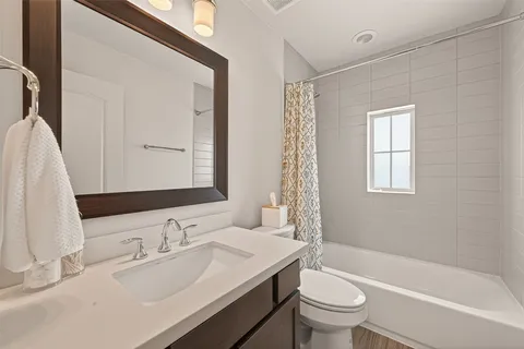 a bedroom with a bed a window and dresser