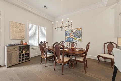 a dining room with furniture a chandelier and kitchen view