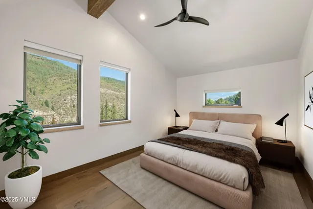 a bedroom with a large bed and a potted plant