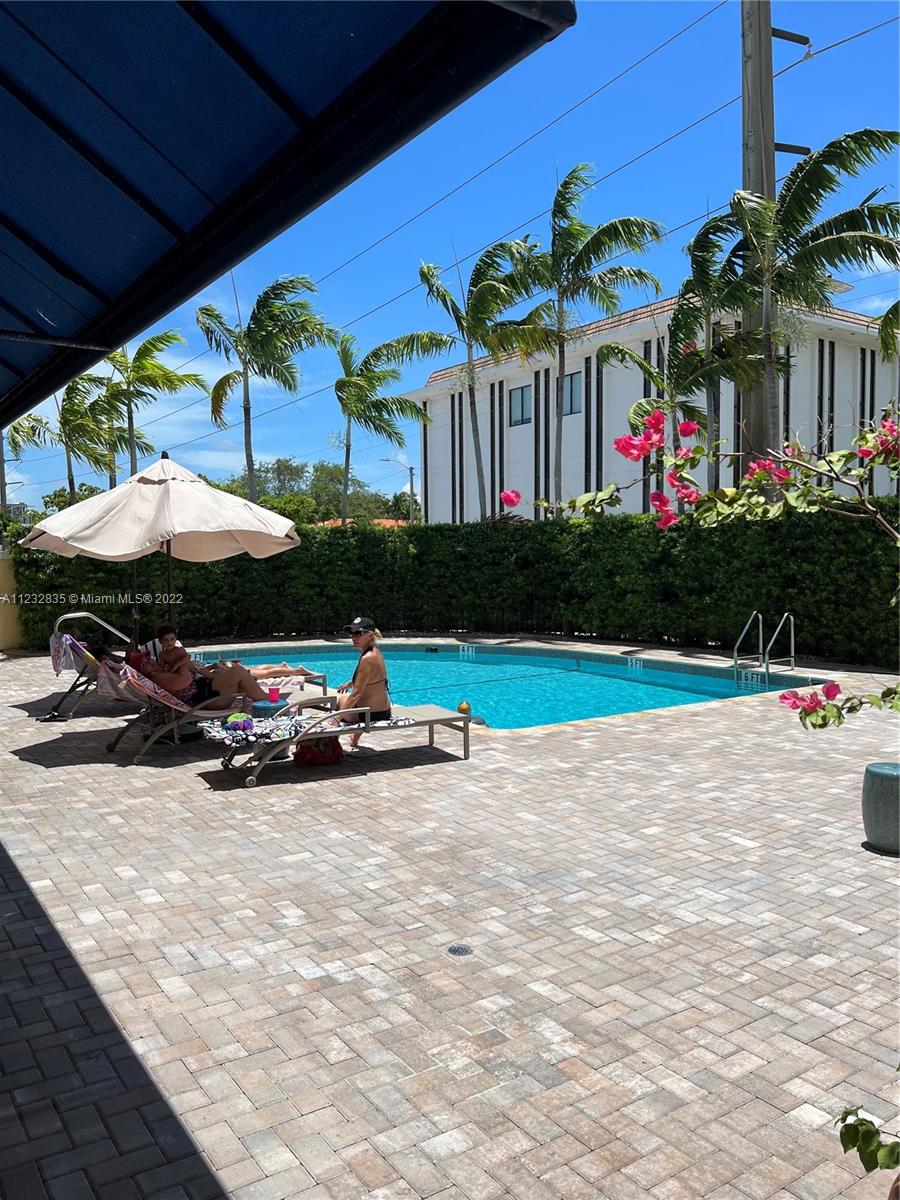 2351 Douglas Road, Unit 910 Miami, FL 33145 - Photo 11 of 24 a view of a patio with table and chairs under an umbrella