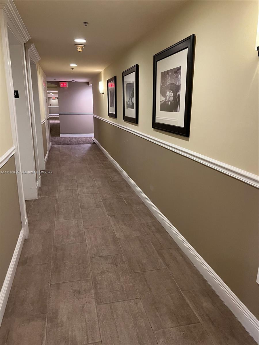 2351 Douglas Road, Unit 910 Miami, FL 33145 - Photo 17 of 24 a view of a hallway with stairs and a refrigerator