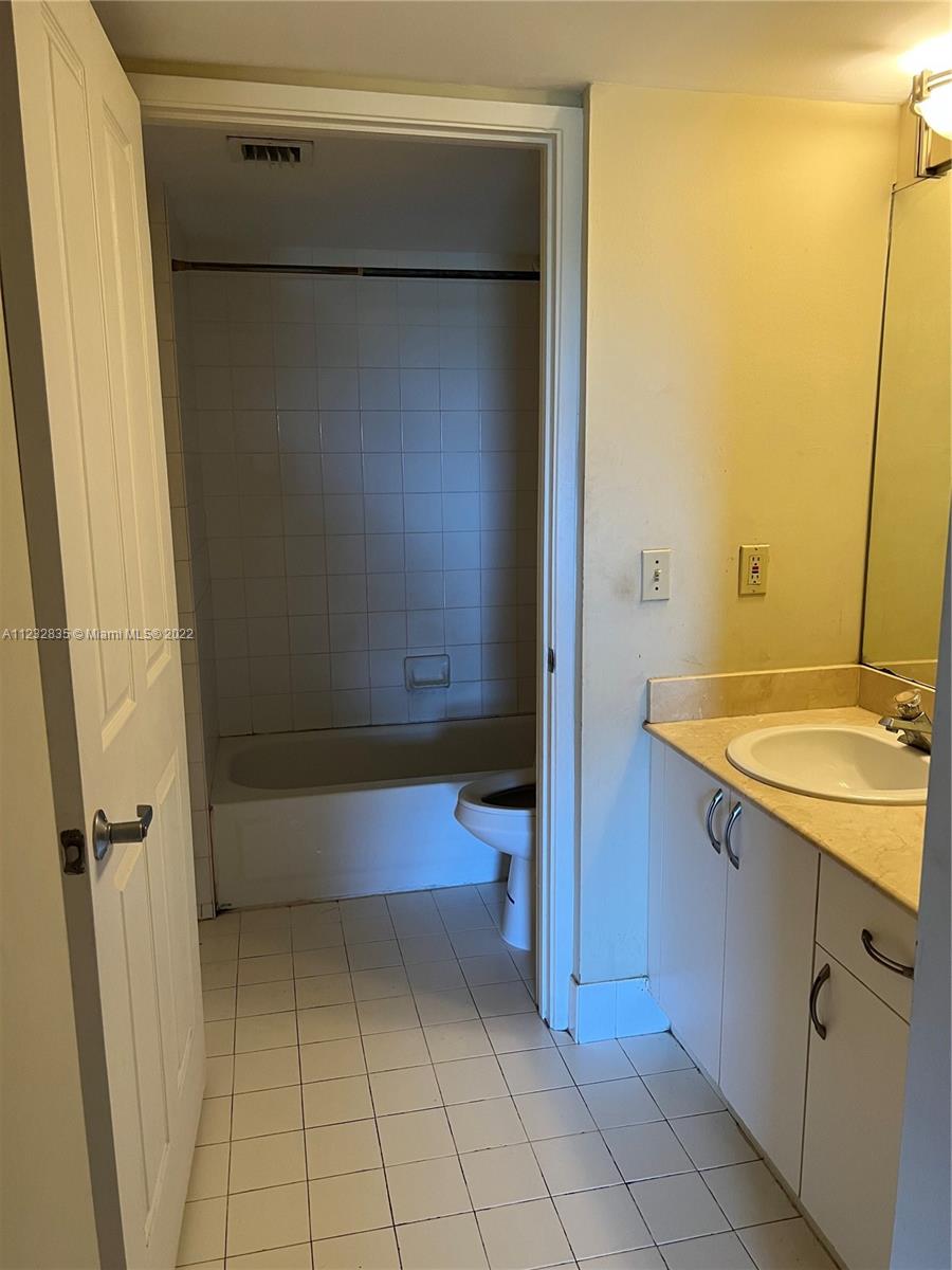 2351 Douglas Road, Unit 910 Miami, FL 33145 - Photo 23 of 24 a bathroom with a sink and mirror