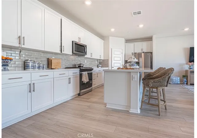 a kitchen with white cabinets stainless steel appliances and sink