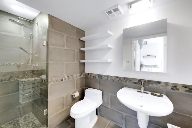 a bathroom with a sink toilet and shower