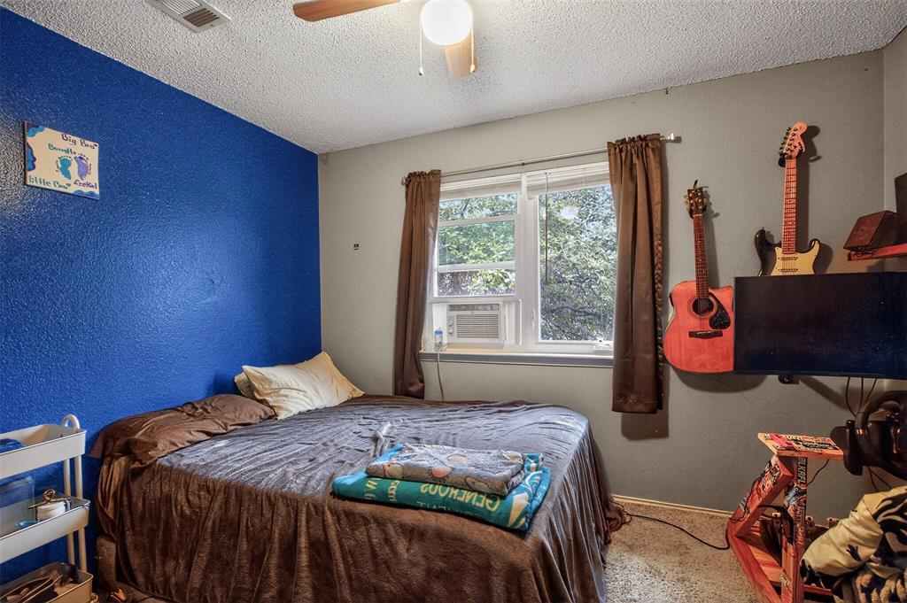 6813 Haltom Road Fort Worth, TX 76137 - Photo 12 of 14 a bedroom with a bed and wooden floor