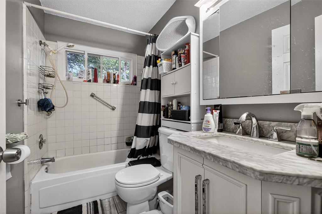 6813 Haltom Road Fort Worth, TX 76137 - Photo 10 of 14 a bathroom with a granite countertop sink toilet and shower