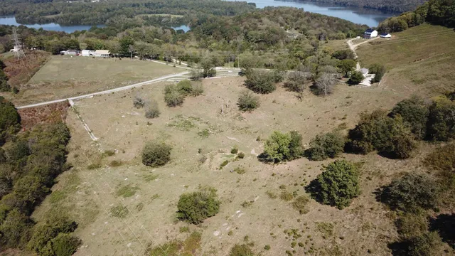 an aerial view of house with yard and mountain view in back