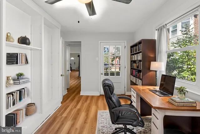 a view of a workspace with furniture and a window