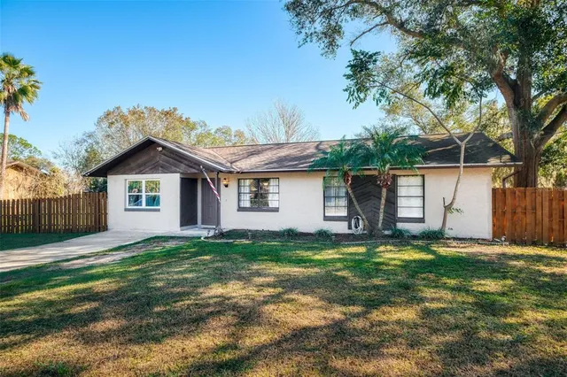 a front view of a house with a yard and trees