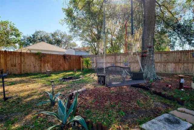 a view of a backyard with plants and large trees