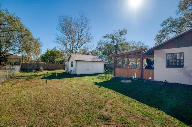 a view of a house with backyard and a tree