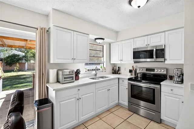 a kitchen with cabinets stainless steel appliances and a window