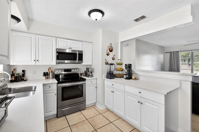 a kitchen with white cabinets stainless steel appliances and sink