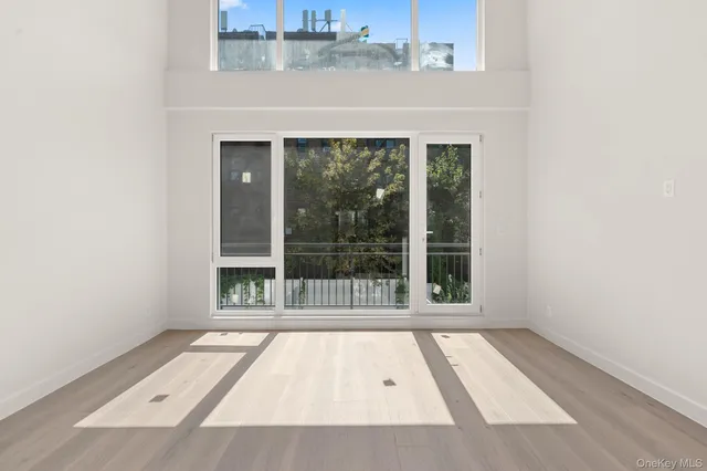 an empty room with wooden floor and a window