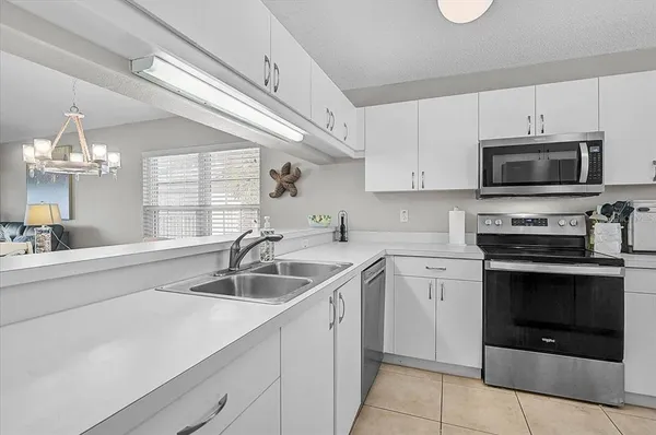 a kitchen with cabinets stainless steel appliances a sink and a counter top space