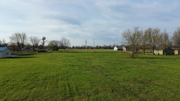 a grassy field with trees in the background