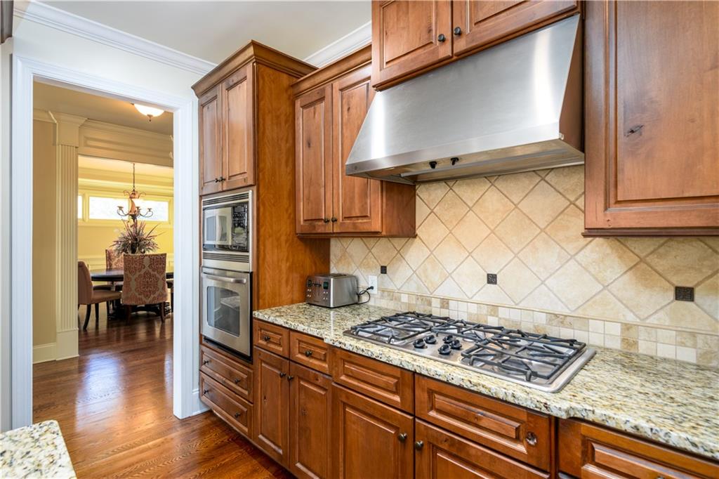 2070 Trinity Mill Drive Dacula, GA 30019 - Photo 11 of 46 a kitchen with wooden cabinets and a stove top oven