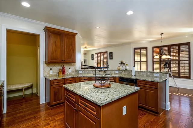 a dining room with wooden floor a chandelier a wooden table and chairs