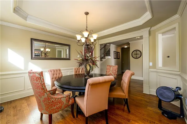 a large kitchen with kitchen island a stove a sink a refrigerator white cabinets and wooden floor