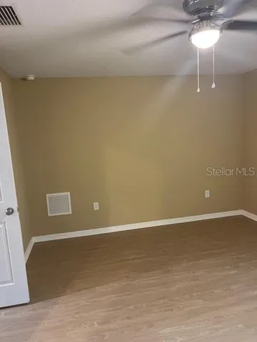 an empty room with a ceiling fan and a window