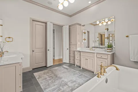 a spacious bathroom with a granite countertop sink a mirror and a bathtub