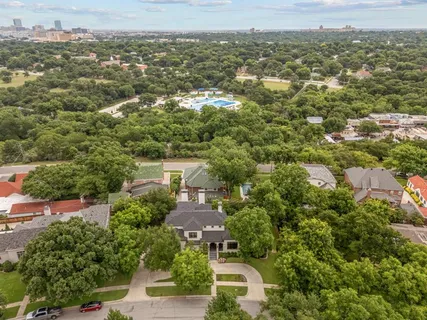 an aerial view of residential houses with outdoor space and trees