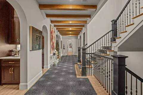 a view of hallway with stairs and wooden floor