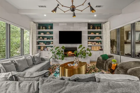 a living room with furniture a fireplace and a flat screen tv