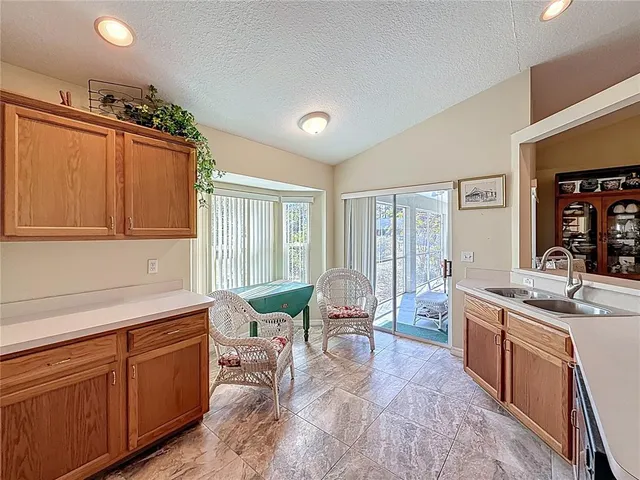 a large kitchen with kitchen island granite countertop a sink and dishwasher a stove with wooden cabinets