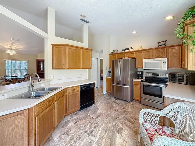 a kitchen with granite countertop a sink stainless steel appliances and cabinets