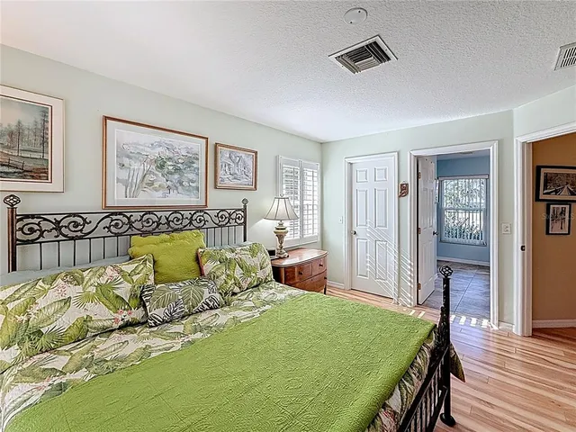 a bed sitting in a spacious bedroom next to a window